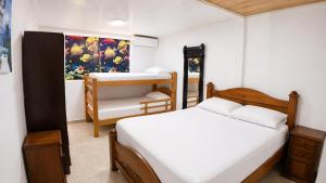 a small bedroom with two beds and a chair at La Gran Casa in San Andrés