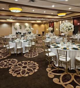 a banquet hall with white tables and chairs and flowers at Hilton Houston Westchase in Houston +24 photos