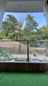 an open window with a view of a field at Healer home in Rishīkesh