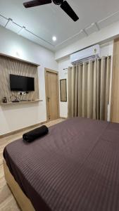 a bedroom with a large bed and a flat screen tv at Healer home in Rishīkesh