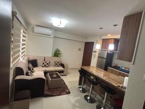 a living room with a couch and a kitchen at Condominio Irala in Santa Cruz de la Sierra