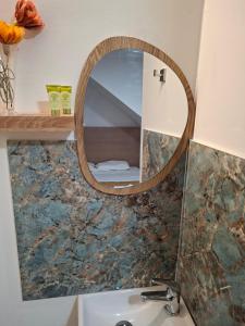a bathroom with a round mirror over a sink at Olympus Pool Retreat in Katerini +10 photos