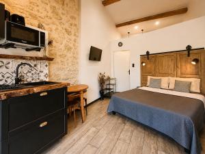 a bedroom with a bed and a desk and a television at L inarretable studio independant in Cézac