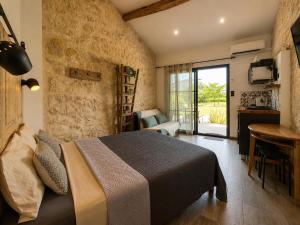 a bedroom with a bed in a room with a balcony at L inarretable studio independant in Cézac