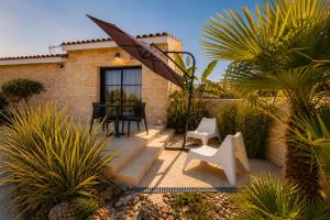 a patio with a table and chairs and palm trees at L inarretable studio independant in Cézac