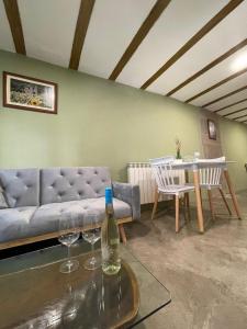 a living room with a couch and a table with wine glasses at Casa O'Tinte in Alquézar