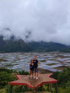 a man and a woman standing on top of a star at Greentea Hostel in Labuhanhaji
