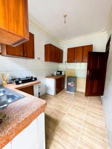 a kitchen with wooden cabinets and a wooden floor at Happy homes stay in Namugongo