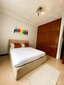 a bedroom with a white bed with a painting on the ceiling at Happy homes stay in Namugongo