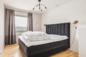 a black bed in a bedroom with a window at Vita Villan - Funäsdalen in Funäsdalen