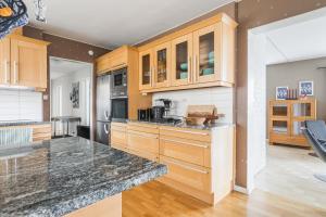 a kitchen with wooden cabinets and a granite counter top at Vita Villan - Funäsdalen in Funäsdalen