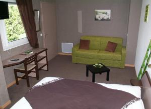Cette chambre comprend un lit, un canapé et une table. dans l'établissement Logis Hotel des Portes de Meuse, à Pagny-sur-Meuse
