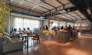 a group of people sitting at tables in a restaurant at VOS Suites By BOLD in Gelugor