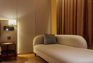 a living room with a couch and a side table at VOS Suites By BOLD in Gelugor
