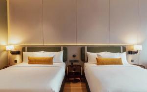 two beds sitting next to each other in a room at VOS Suites By BOLD in Gelugor