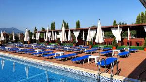a group of chairs and umbrellas next to a swimming pool at GARDEN Club - Hotel & Restaurant - FREE Outdoor Pool & Parking in Braşov