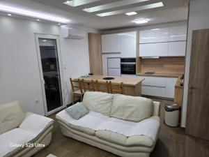 a living room with a couch and a kitchen at Serbian home - free parking - Bazen se doplaćuje in Krnjača