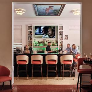 a bar in a restaurant with people sitting at it at Avalon Hotel in Miami Beach