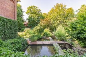 a bridge over a pond in a garden at Alte Wassermuehle Hollebek in Bredstedt