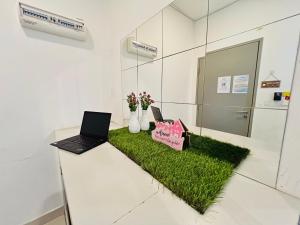 a desk with a laptop on a patch of grass at Comfort Zone Premium Guesthouse @ Evo Bangi in Bangi +102 photos