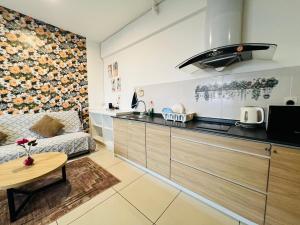 a kitchen with a couch and a table in a room at Comfort Zone Premium Guesthouse @ Evo Bangi in Bangi
