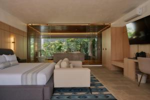 a bedroom with a bed and a couch and a window at Casa Carmen Xólotl in Oaxaca City