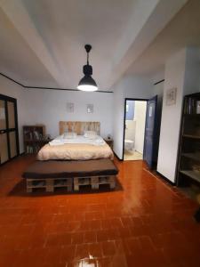a bedroom with a bed and a brick floor at l'Estagnol in Ansouis