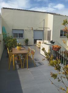 a patio with a table and chairs on a building at Casa Afonso Guesthouse in Ferrel