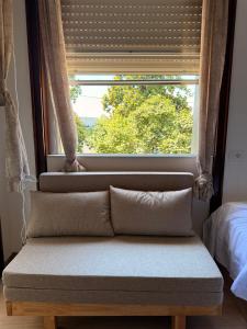 a bench in front of a window with a window shade at Happy Hue rooms Malpensa airport in Samarate +12 photos