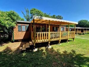 a small house with a porch with a roof at Camping Paus'Art Déco in Villemer