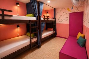 a bunk bed room with two bunk beds and a couch at Chillout Hostel Barrio Escalante in San José