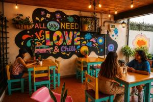a group of people sitting at tables in a restaurant at Chillout Hostel Barrio Escalante in San José