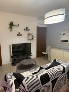 a living room with a couch and a tv at Illumina House 2 in Giurdignano