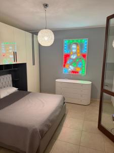 a bedroom with a bed and a painting on the wall at Illumina House 2 in Giurdignano