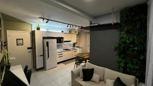 a living room with a couch and a kitchen at Apartamento Moderno em Floripa - Ideal para Famílias in São José