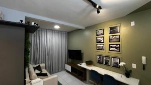 a living room with a couch and a tv on a wall at Apartamento Moderno em Floripa - Ideal para Famílias in São José