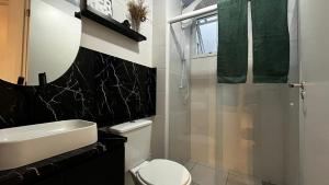a bathroom with a white toilet and a sink at Apartamento Moderno em Floripa - Ideal para Famílias in São José +31 photos