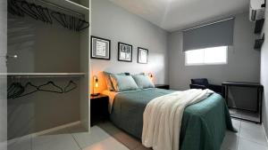 a bedroom with a green bed and a television at Apartamento Moderno em Floripa - Ideal para Famílias in São José