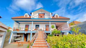 a house with stairs leading up to it at O Cantinho do Pargo in Ponta do Pargo