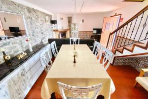a dining room with a white table and chairs at O Cantinho do Pargo in Ponta do Pargo