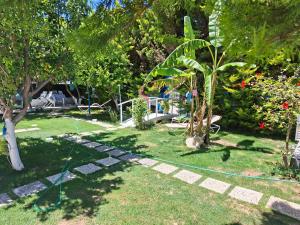a garden with a green hose in the grass at Hotel Antonio in Çeşme