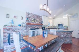 a kitchen with a wooden table and a brick wall at Shell Station House in Folly Beach