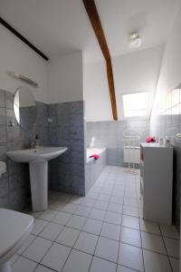 a white bathroom with a sink and a mirror at Ferme de Lamourio in Saint-Cernin