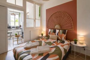 a bedroom with a large bed and a kitchen at Chamotte Hyper Centre WIFI Cosy in Bourg-en-Bresse