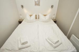 a white bed with two white towels on it at Tiny Chalet Nr 814 in Göhren