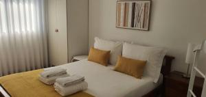 a bedroom with a bed with towels on it at Casa de Salgueiros in Canidelo +23 photos