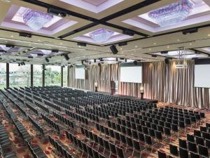 a large auditorium with rows of chairs and screens at Pullman Melbourne Albert Park in Melbourne +116 photos