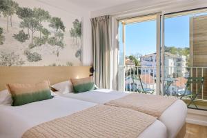 a bedroom with two beds and a large window at Best Western Arcachon Le Port in Arcachon