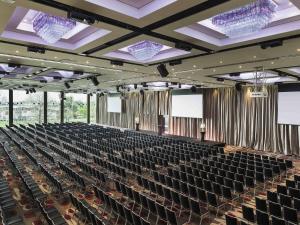 an empty auditorium with black chairs and two screens at Mercure Melbourne Albert Park in Melbourne +129 photos