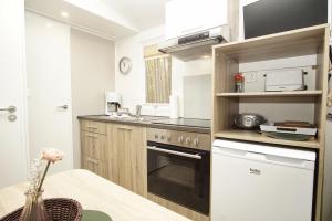 a kitchen with a stove and a sink at Tiny Chalet Nr 819 in Göhren +15 photos